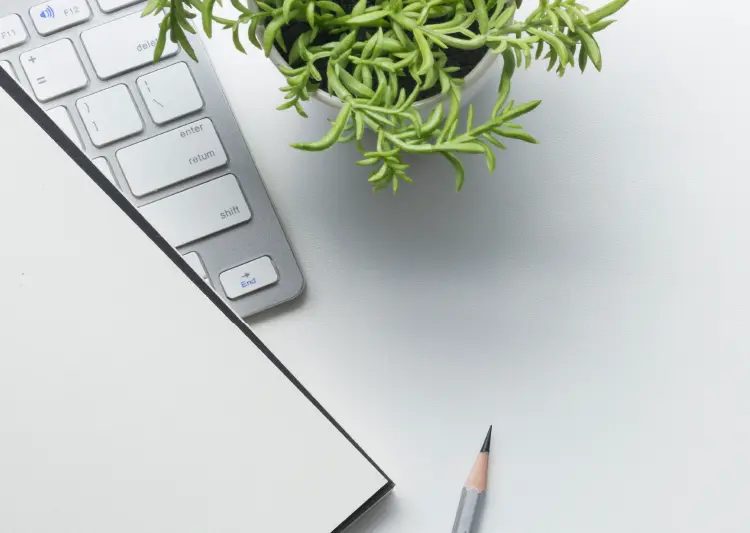 Keyboard, pencil and notepad on a clean desk